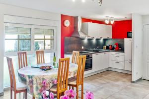 a kitchen with a table and chairs and red walls at Maison charmante à Stotzheim + jardin in Stotzheim +14 photos