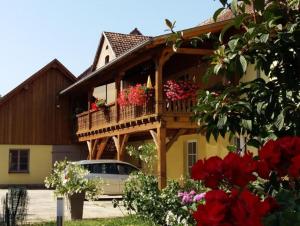 a house with a balcony with flowers on it at Maison charmante à Stotzheim + jardin in Stotzheim
