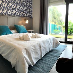 uma grande cama branca num quarto com uma janela em Casas adosadas julieta em Ribadesella