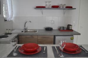 a kitchen with red plates and glasses on a table at A Place to Relax 2 in Nisaki