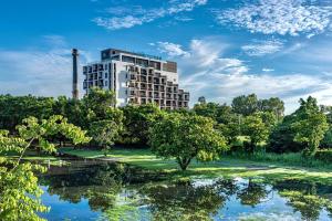 a building in the middle of a park with trees at Just Sleep Tainan in Tainan