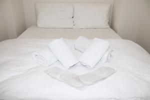 Una cama blanca con tres toallas blancas. en Royal Suite, en Pamukkale