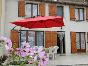 una sombrilla roja en un patio con sillas y flores en Gîte Champigny-sous-Varennes, 3 pièces, 5 personnes - FR-1-611-2, 