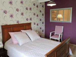 1 dormitorio con cama y pared púrpura en Gîte Chaumont-la-ville, 2 pièces, 2 personnes - FR-1-611-36, 