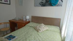 a bedroom with a bed with a pillow and a desk at Room in Guest room - Double Room private shower room deg-yr in Hayes