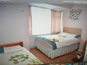 a small bedroom with two beds and a window at Tiny Single shared bathroom Room ssbyr in Hayes