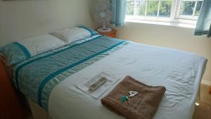 uma cama com um par de tesouras e uma almofada em Room in Guest room - Double with shared bathroom sleeps 1-2 located 5 minutes from Heathrow dsbyr em Hayes