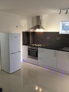 a kitchen with a white refrigerator and a stove at Small Modern Comfortable 2 Bedroom Apartment cmyr in Hayes