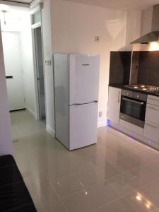 a kitchen with a white refrigerator and a stove at Small Modern Comfortable 2 Bedroom Apartment cmyr in Hayes