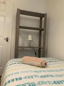 a bed with a wooden bed frame next to a lamp at Small Modern Comfortable 2 Bedroom Apartment cmyr in Hayes