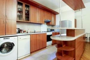 a kitchen with wooden cabinets and a washer and dryer at 2 Bedroom Apartment on Chaikovski street in Yerevan