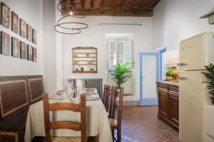 a dining room with a table and a refrigerator at Il Giardino del Cardinale - Deb'S Monticchiello in Monticchiello