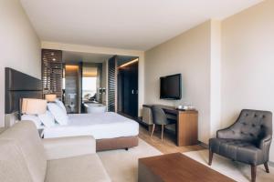 a hotel room with a bed and a desk and a chair at Iberostar Selection Lagos Algarve in Lagos