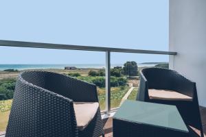 a balcony with two chairs and a glass table at Iberostar Selection Lagos Algarve in Lagos