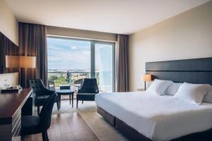 a hotel room with a bed and a desk and a window at Iberostar Selection Lagos Algarve in Lagos