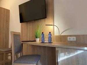 twee flessen water op een aanrecht met een tv bij Hotel Gloria in Alsdorf