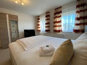 a bedroom with a large white bed with towels on it at Hotel Gloria in Alsdorf