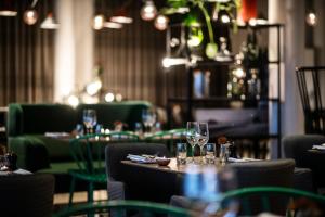 a restaurant with tables and chairs with wine glasses at Frösö Park Hotel in Östersund