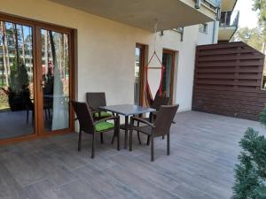 a patio with a table and chairs on a patio at Apartament Rodzinny Baltic Park Stegna in Stegna