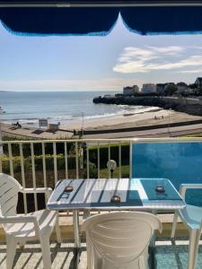 d'une table et de chaises sur un balcon avec vue sur la plage. dans l'établissement Logis de Mélisandre, à Vaux-sur-Mer