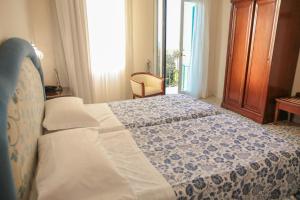 a bedroom with a bed with a blue and white quilt at Hotel La Badia in Sorrento