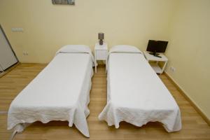 two beds in a hospital room with white sheets at Barcelona City Apartment in Barcelona