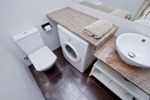 a bathroom with a toilet and a sink and a washing machine at Barcelona City Apartment in Barcelona