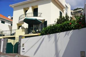 een wit gebouw met een paraplu op een balkon bij !Your Home In Madeira in Funchal