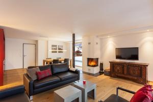 a living room with a couch and a fireplace at Serviced Apartment ELITE in Saas-Fee