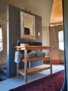a table with a mirror and a sink in a room at Grysbokkloof Private Nature reserve luxury Glamping 6km from Montagu in Montagu