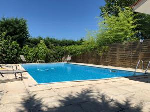 Una piscina en un patio junto a una valla. en La Maison des Brandes, en Eynesse