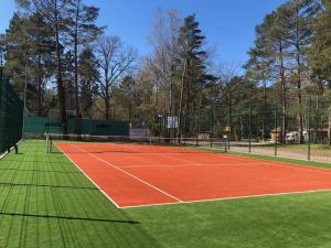 a tennis court with a net on top of it at Apartament na Leśnej in Pobierowo