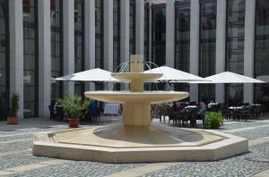 a fountain in front of a building with tables and umbrellas at Haus St. Joseph in Waldsassen