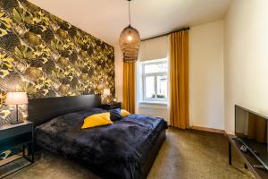 ein Schlafzimmer mit einem großen Bett und einem TV in der Unterkunft Liepaja Apartments in Liepāja