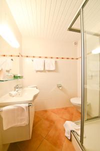 a bathroom with a toilet and a sink and a shower at Gästehaus Heimgarten in Bad Wiessee +42 photos