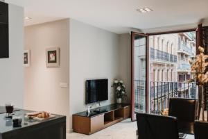 a living room with a tv and a large window at Signa Juristas in Valencia