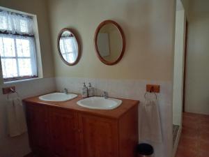 a bathroom with two sinks and a mirror on the wall at Avondrust Guest House in Graaff-Reinet