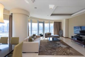 Ultimate Luxury at Fashion Avenue Dubai Mall Residences في دبي: غرفة معيشة بها أريكة وتلفزيون