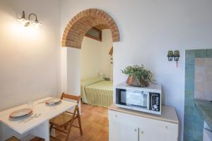 una cucina con tavolo e forno a microonde su un bancone di Casa Germana by HelloElba a Portoferraio