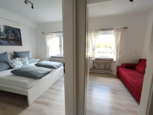 salon z łóżkiem i czerwoną kanapą w obiekcie Steepleview House w mieście Bad Peterstal-Griesbach