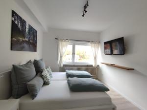 a white living room with a couch and a window at Steepleview House in Bad Peterstal-Griesbach