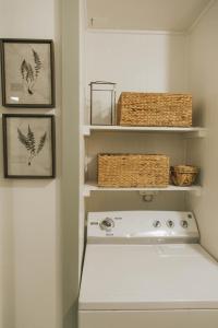 a white laundry room with baskets and a stove at The Woodlawn Tudor in Hot Springs