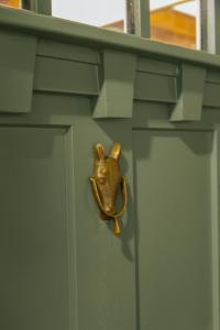 a door knocker of a dog head on a green door at The Woodlawn Tudor in Hot Springs