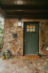 una puerta verde en un edificio de piedra con una pared de piedra en The Woodlawn Tudor, en Hot Springs