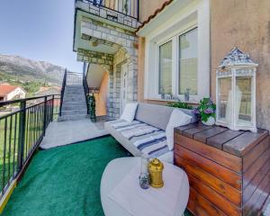 a patio with a couch and a table on a balcony at Apartments Pelle in Tivat