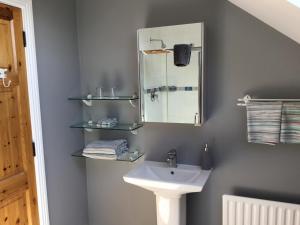 y baño con lavabo y espejo. en Knockaguilla House Bed & Breakfast en Doolin