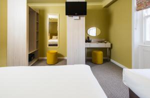 a hotel room with a television and a bed at Caring Hotel in London
