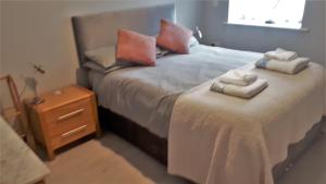 ein Schlafzimmer mit einem großen Bett mit Handtüchern darauf in der Unterkunft 1 Fox Studios in Much Wenlock