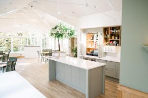 una cocina con armarios blancos y una gran isla en Mulberry House en Ongar