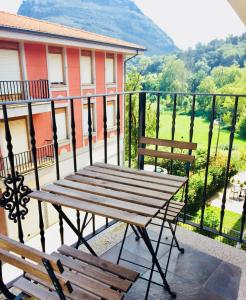 einen Holztisch und zwei Bänke auf einem Balkon in der Unterkunft Ramales garaje incluido, La casita de Nani, entre río y montañas wifi free in Ramales de la Victoria